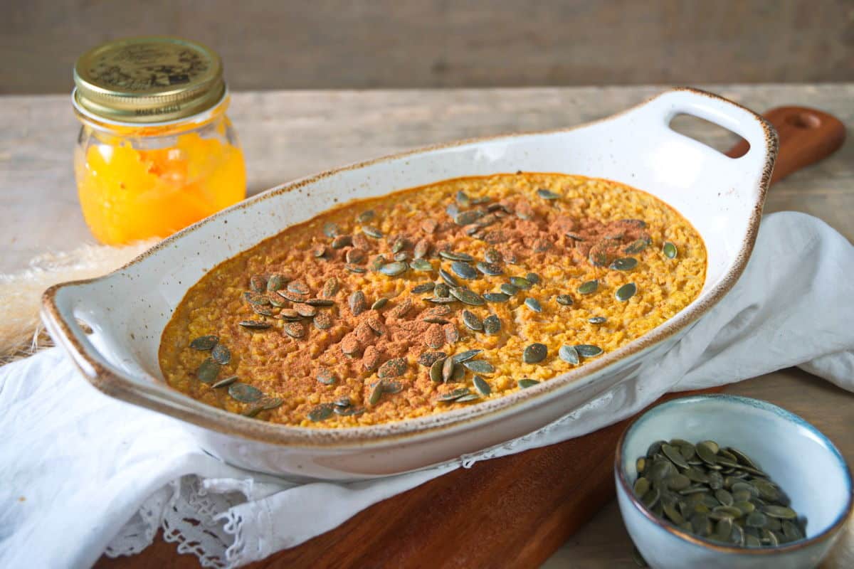 Baked pumpkin spice oatmeal in a white casserole dish.