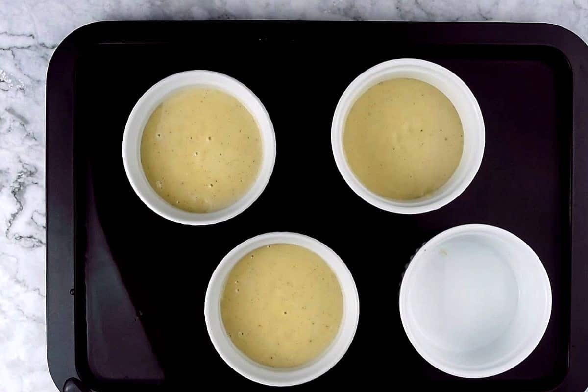 Crème Brûlée custard in ramekins on sheet pan.