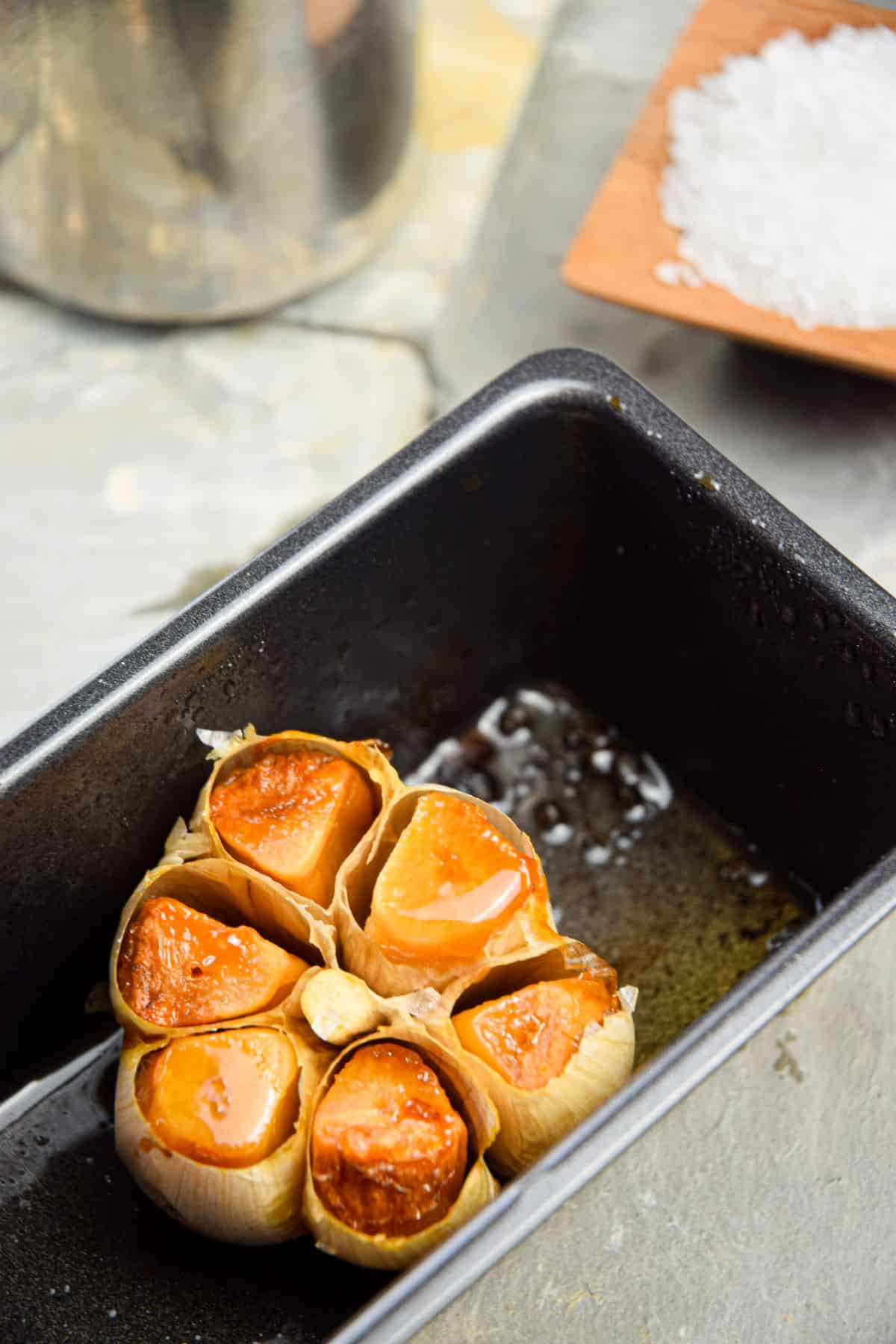 Roasted garlic head in loaf pan.