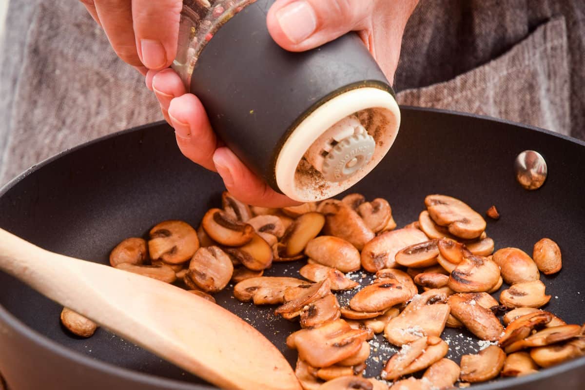 Sautéed mushrooms in pan with salt and pepper.
