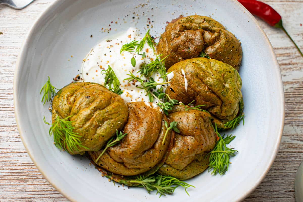 Spinach egg bites on a white plate with fresh dill.