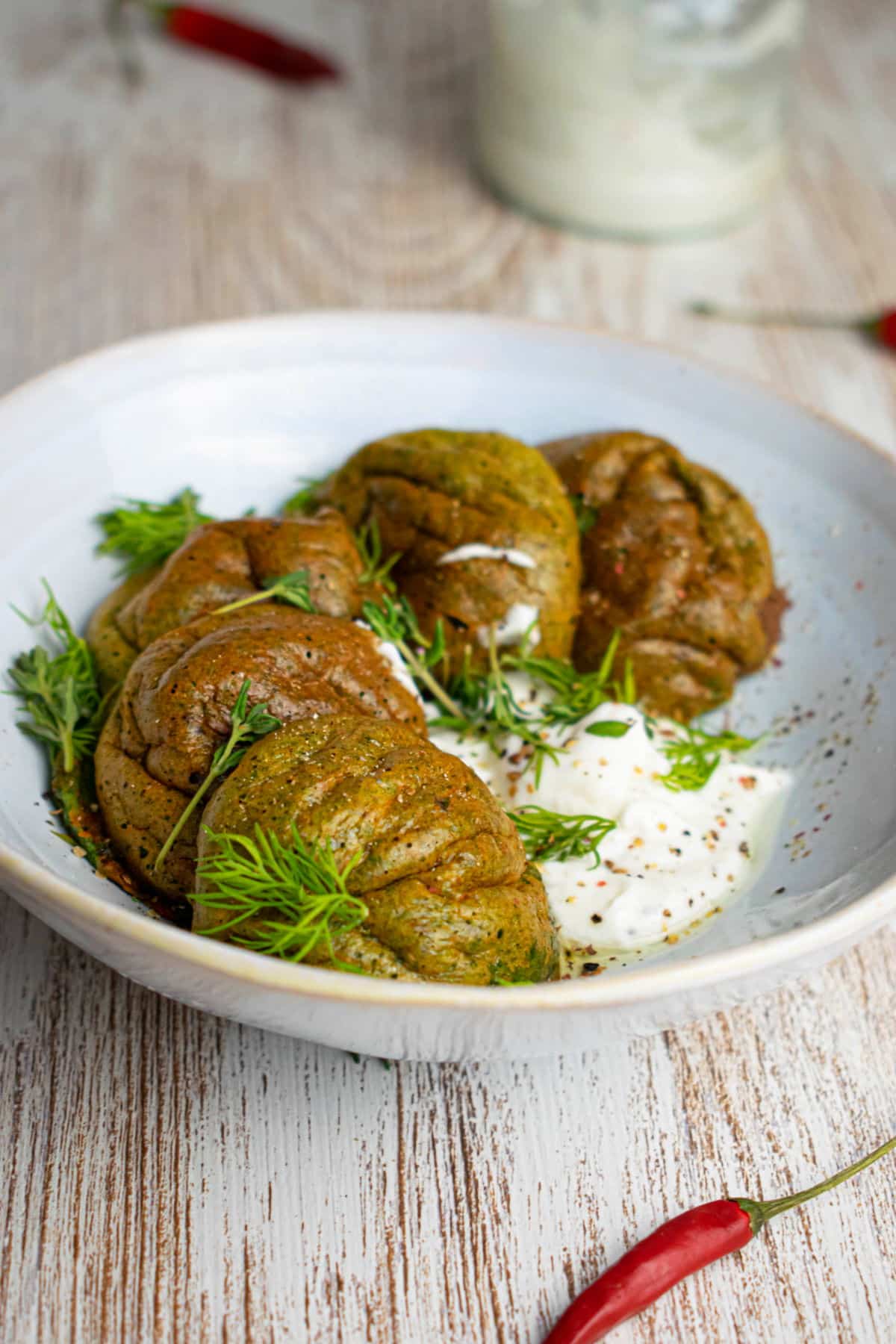Spinach egg bites on a white plate with fresh dill.