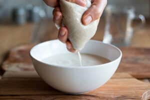 Nut milk squeezing through a nut milk bag.