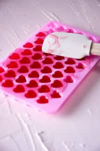 Strawberry candy mixture spread out in a pink heart mold.