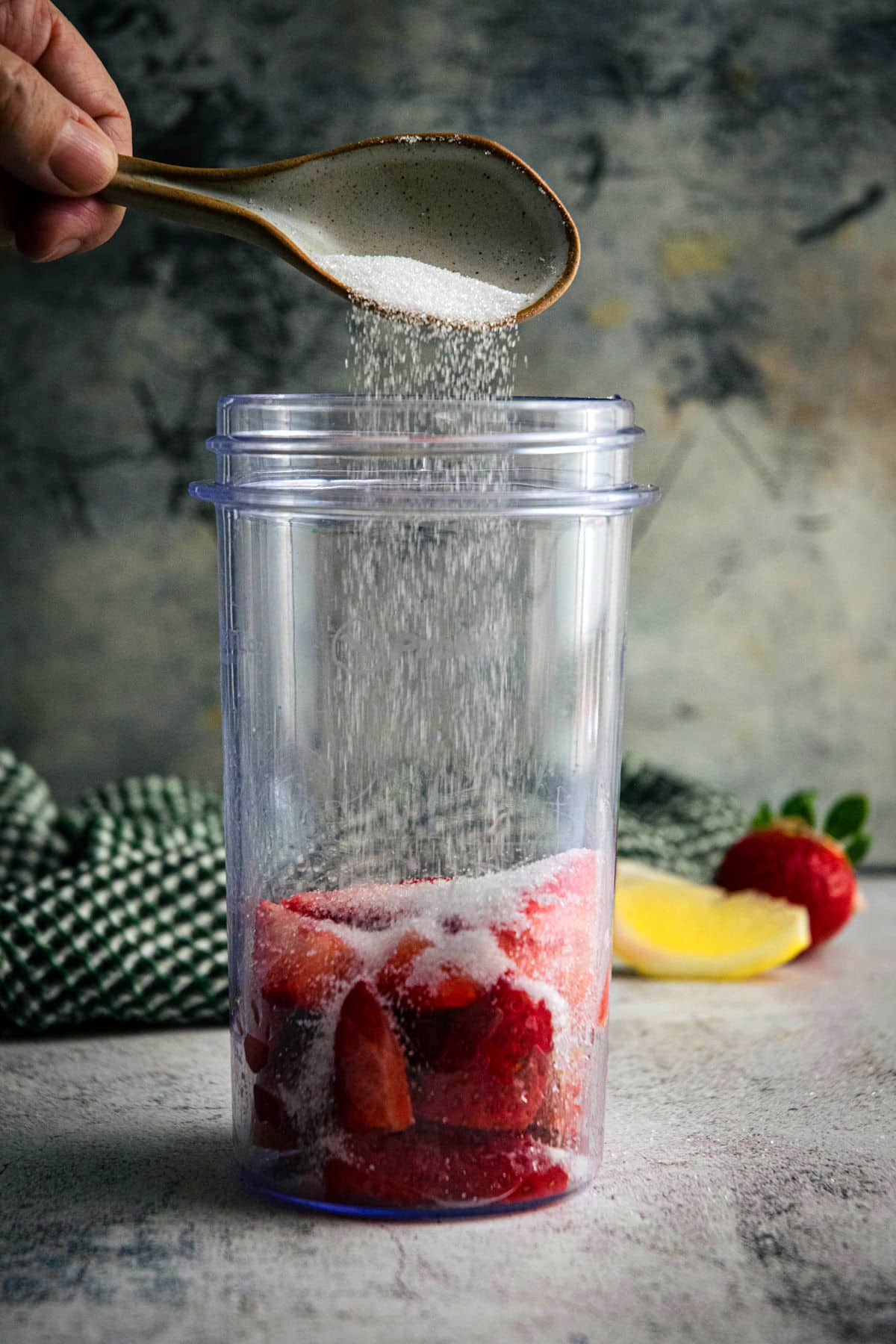 Strawberries and sugar in a blender jar.