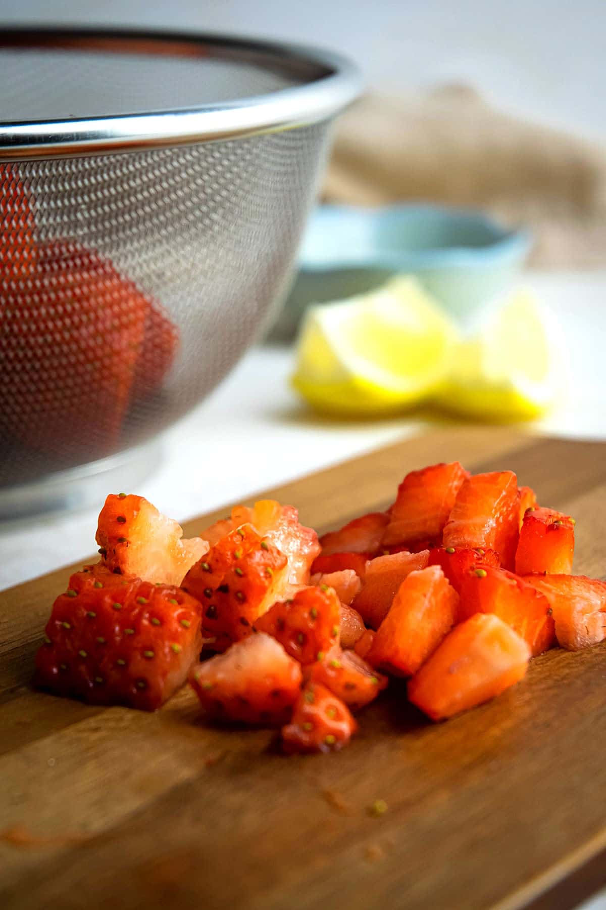 Chopped fresh strawberries on cutting board.