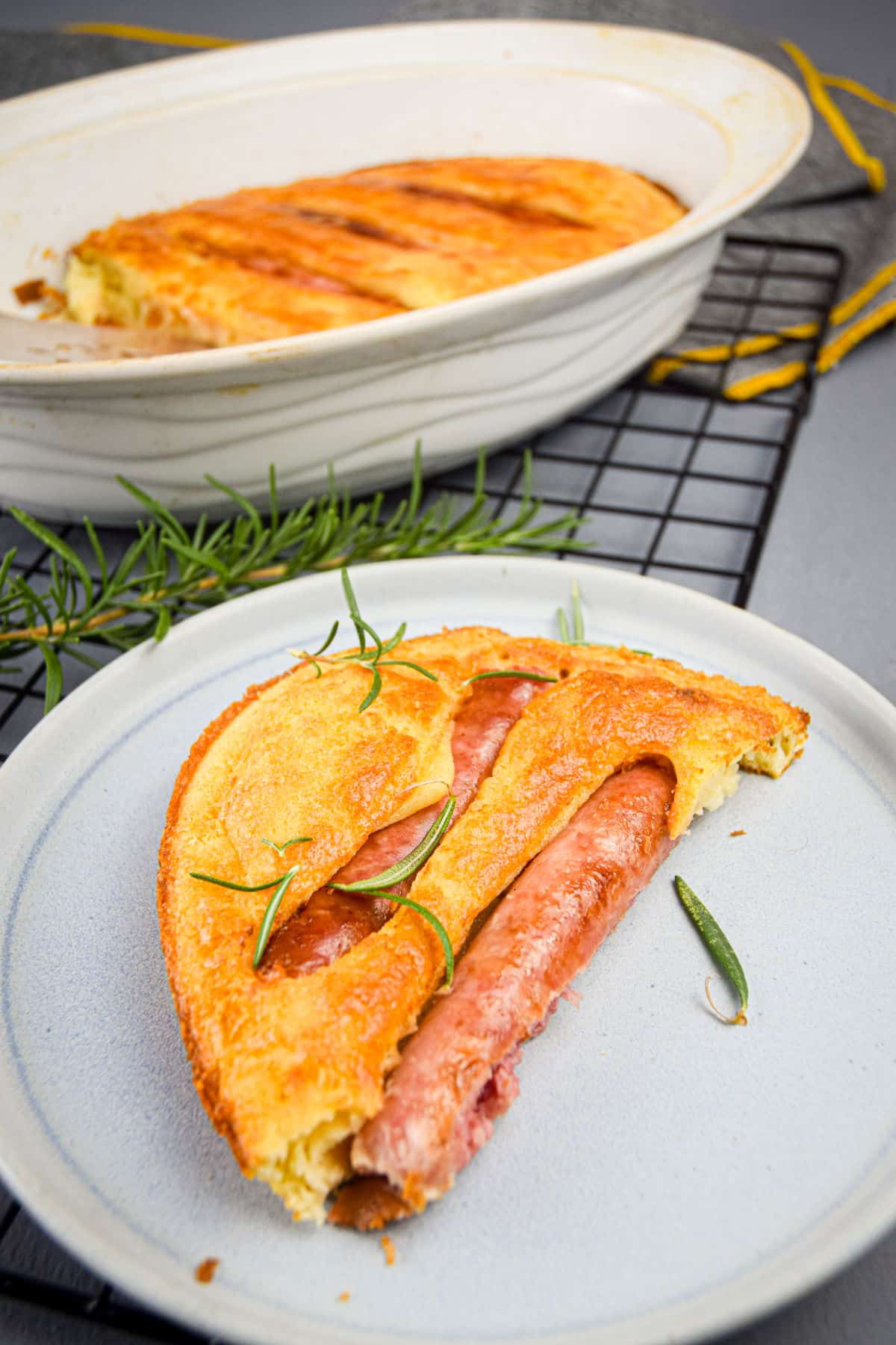 A piece of toad in the hole on a white plate.