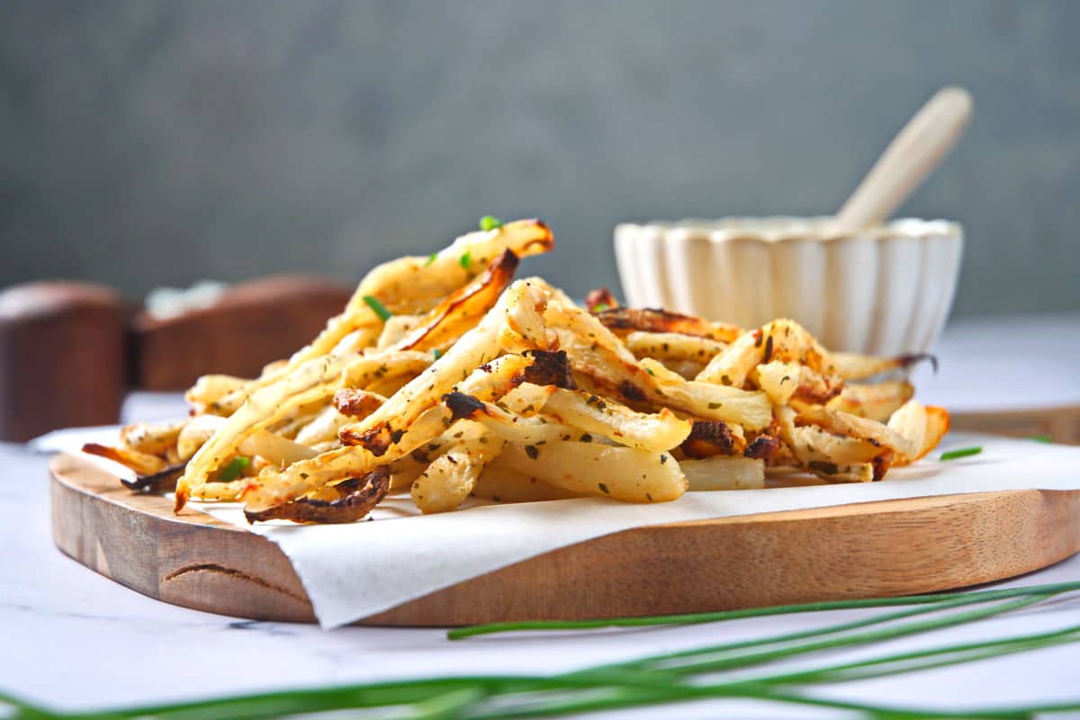 Golden turnips fries on parchment-lined cutting board.