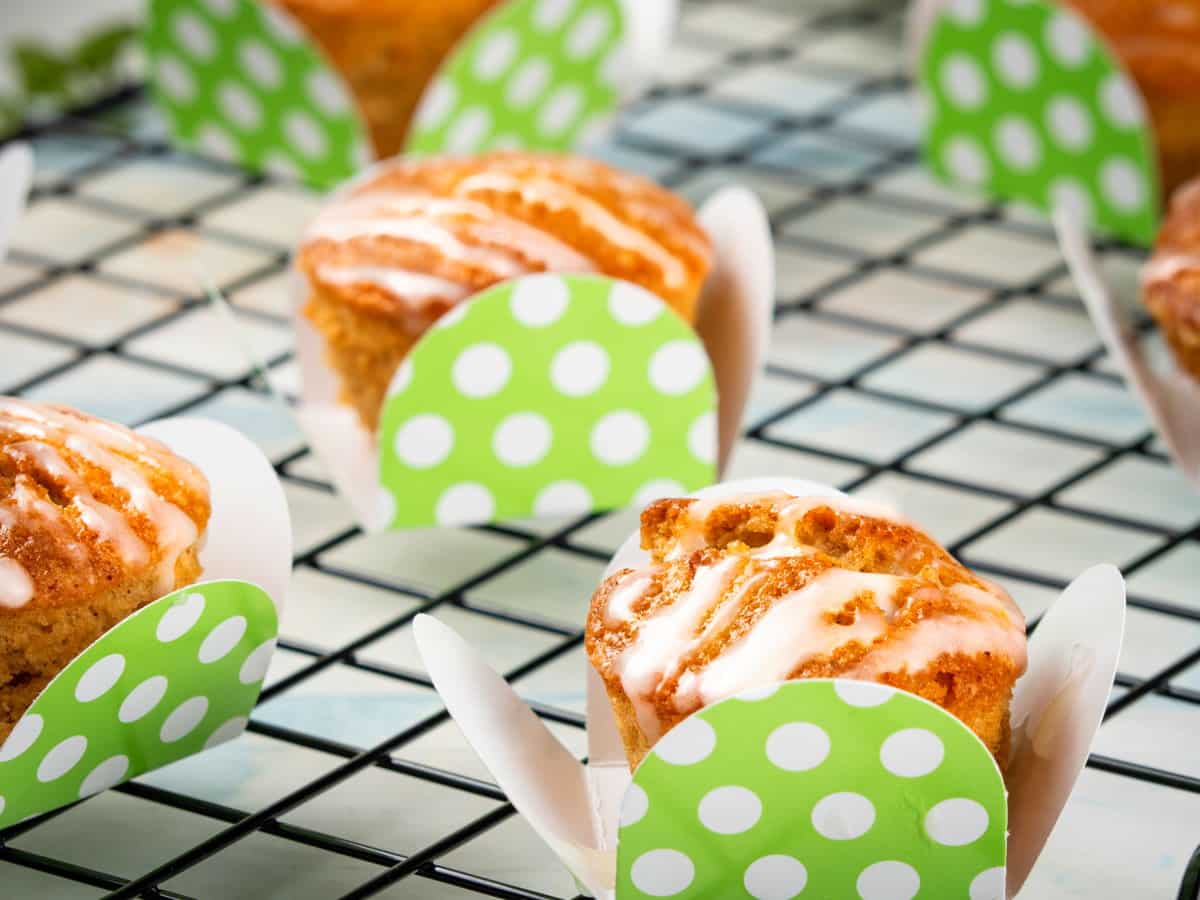 Vegan Gluten Free carrot cupcakes with vegan cream cheese frosting on rack.