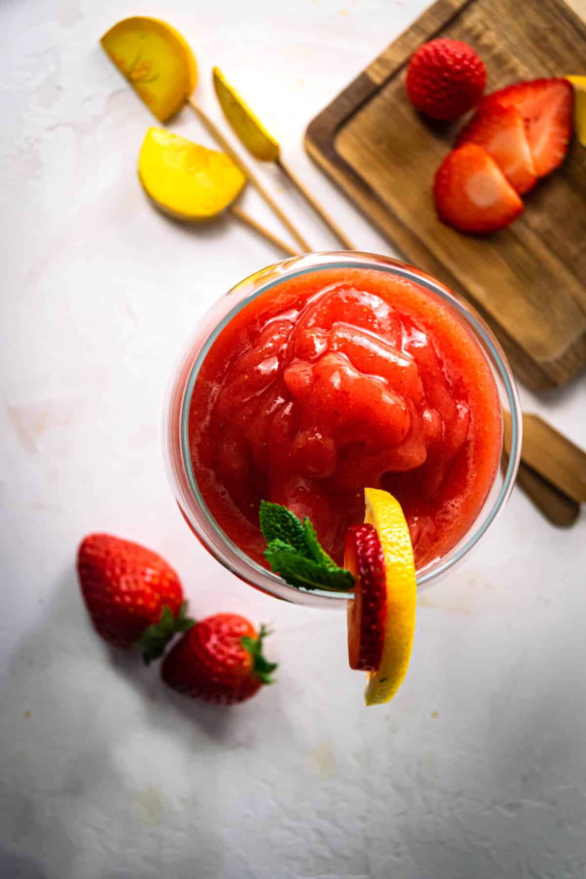 Virgin strawberry daiquiri in a wine glass with garnish.