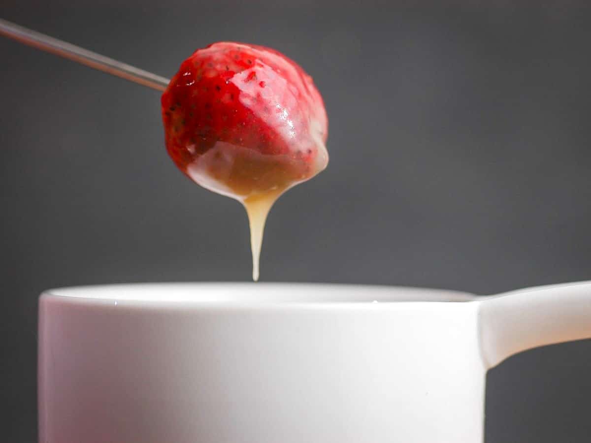 How to Make White Chocolate Ganache - Step 5 Strawberry dipped into white chocolate ganache.