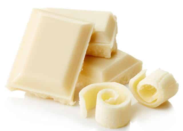 White chocolate pieces, white background.