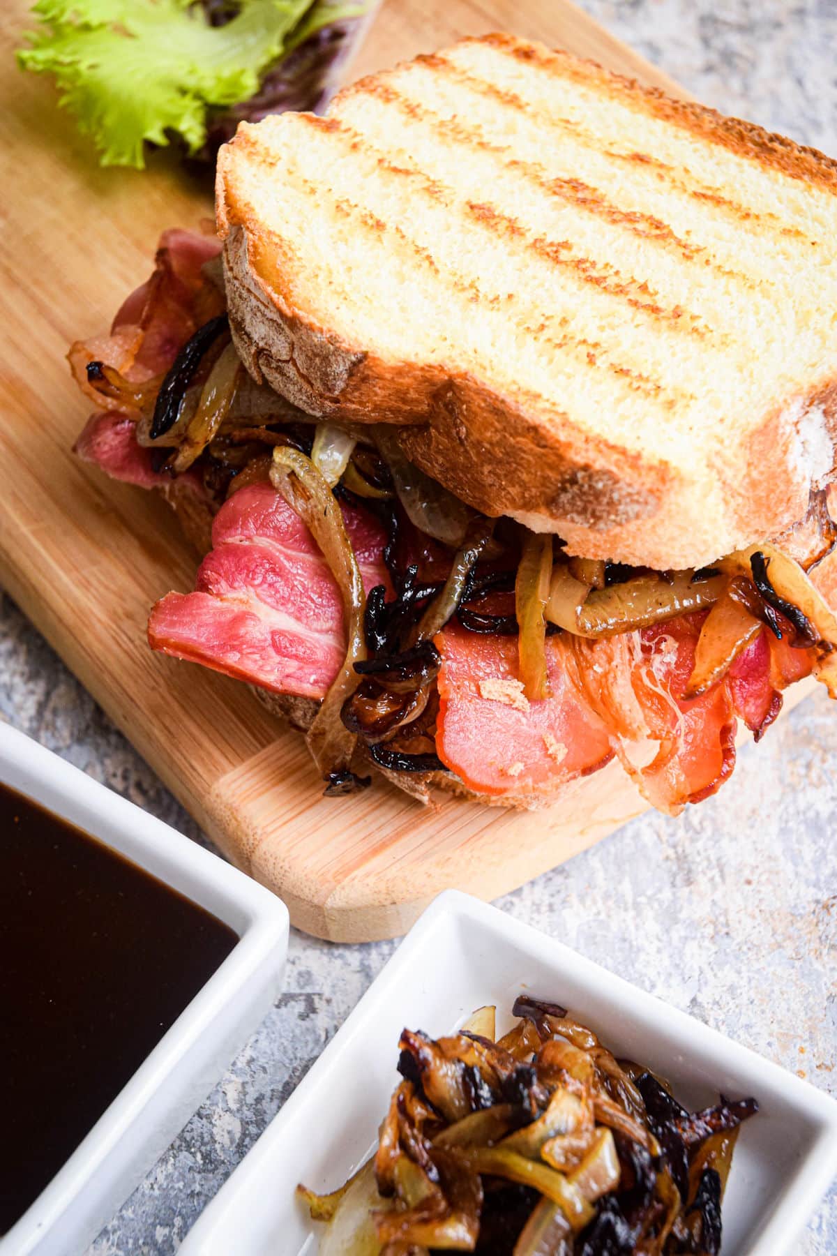 Toasted bacon butty sandwich with caramelized onions and brown sauce.
