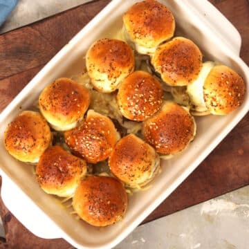 Baked bison sliders in white casserole dish.