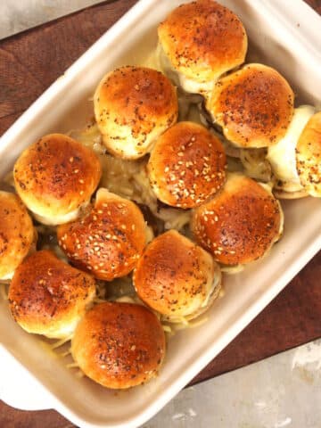 Baked bison sliders in white casserole dish.