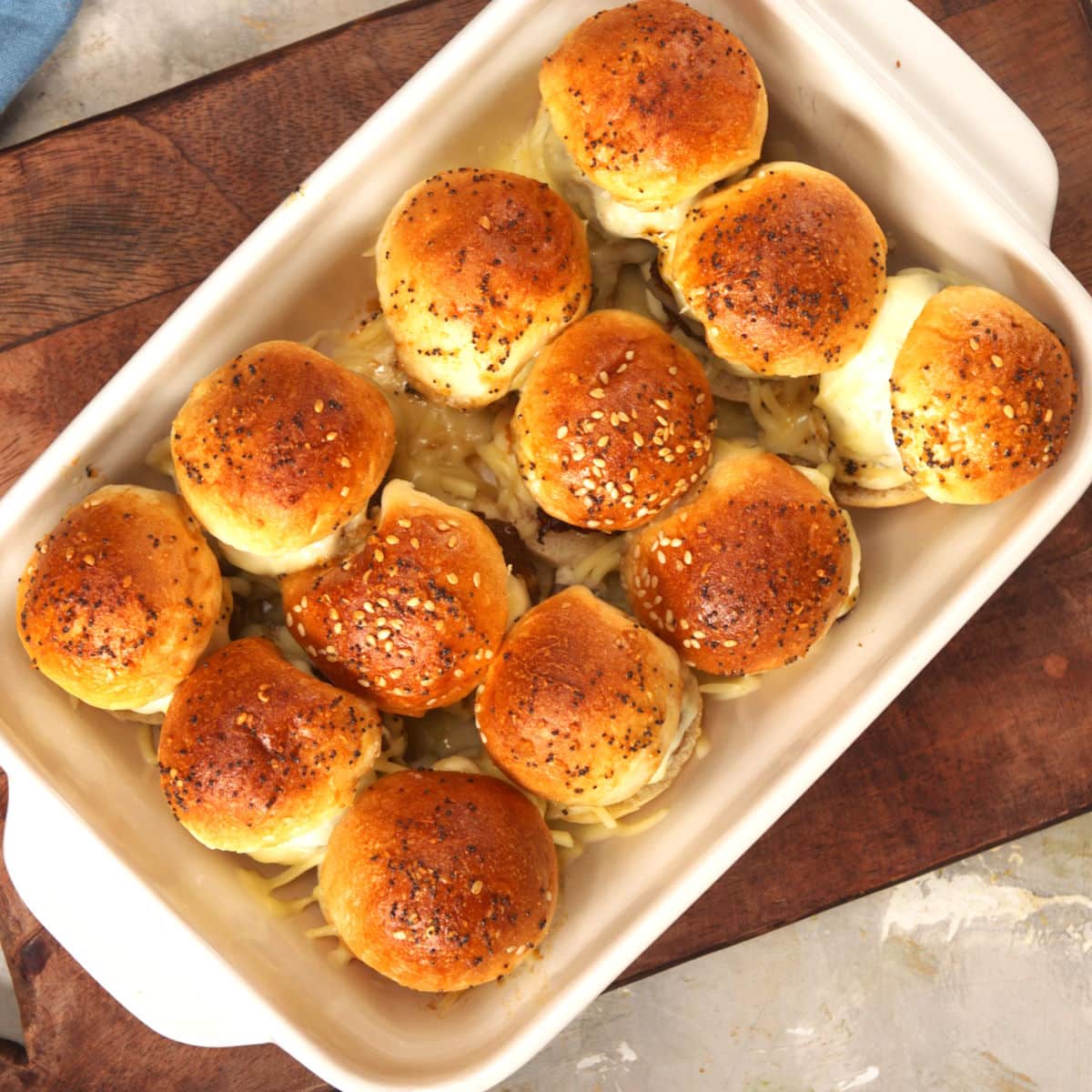 Baked bison sliders in white casserole dish.