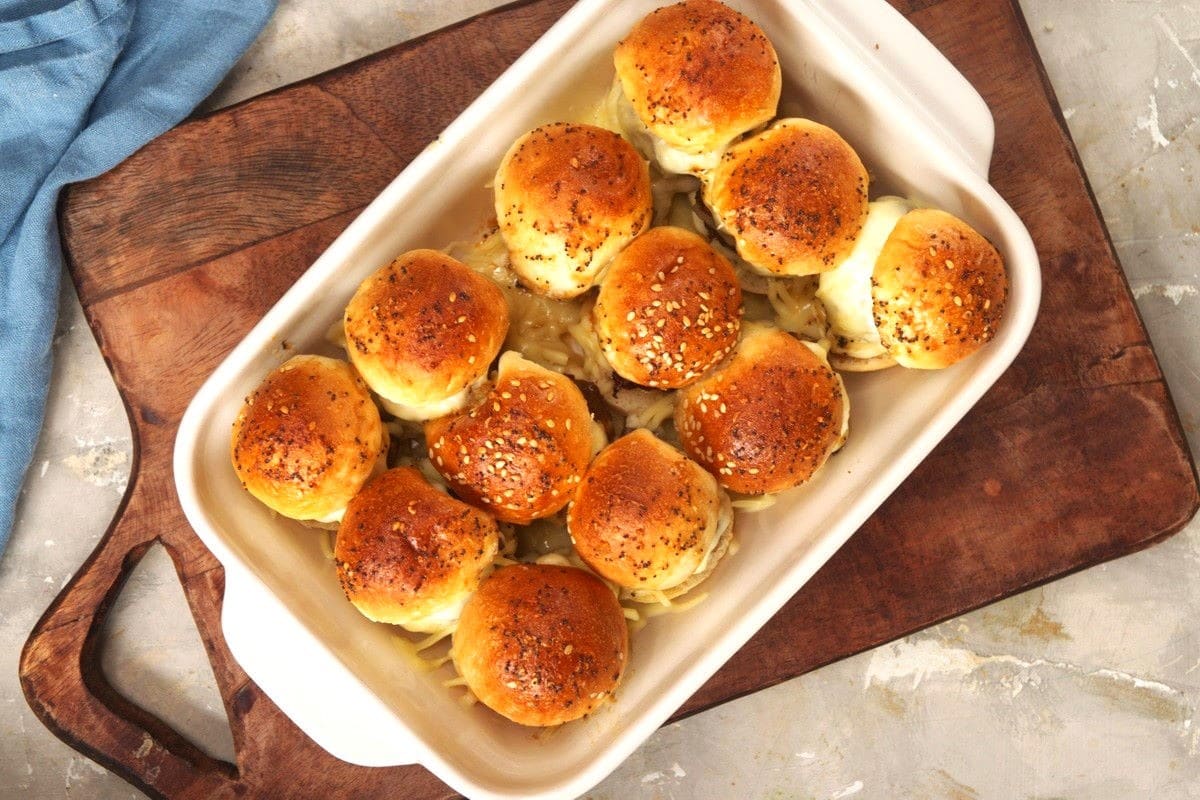 Oven-baked bison meatball sliders in white casserole dish.