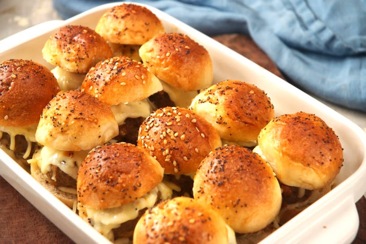 Bison meatball sliders with melted mozzarella in casserole dish.