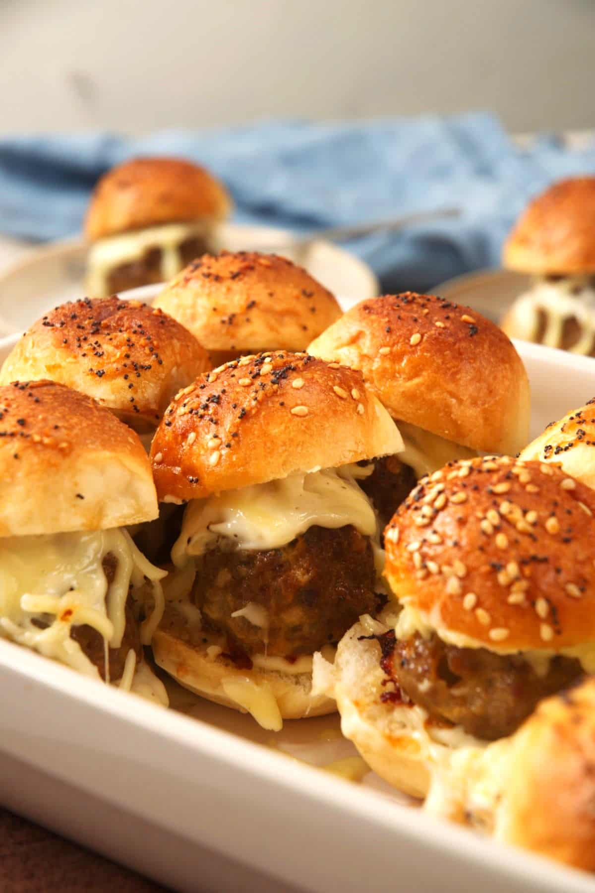 Bison sliders with melted cheese in casserole dish.