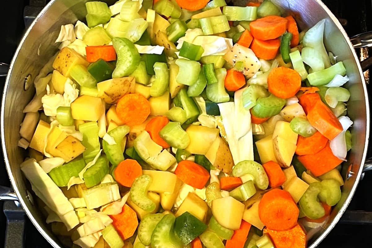 Vegetables and ground beef in large pot.