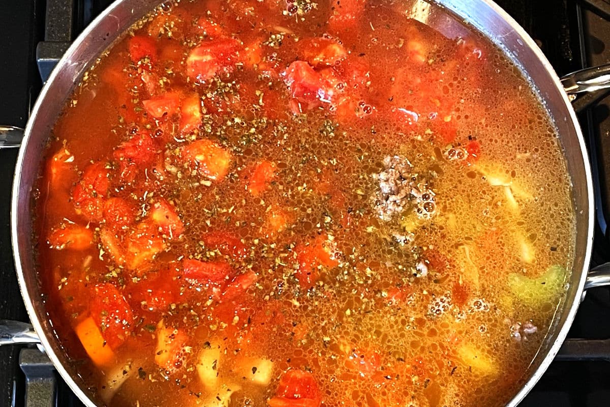 Beef and cabbage soup simmering in large pot.