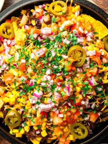 Bison brisket nachos in cast iron pan.