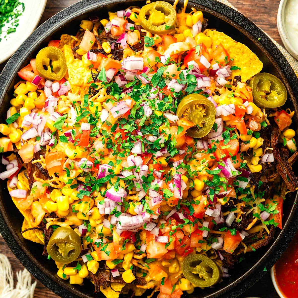 Bison brisket nachos in cast iron pan.