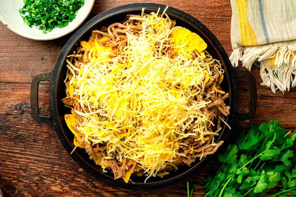Tortilla chips, cheese and bison brisket layered in cast iron pan.