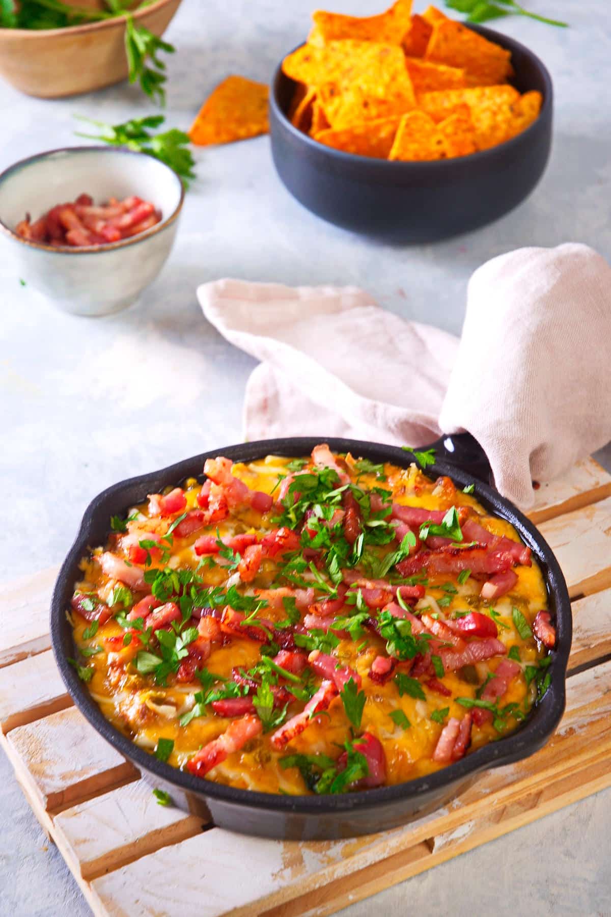 Bison cheeseburger dip in a cast iron pan with a kitchen towel on the handle.