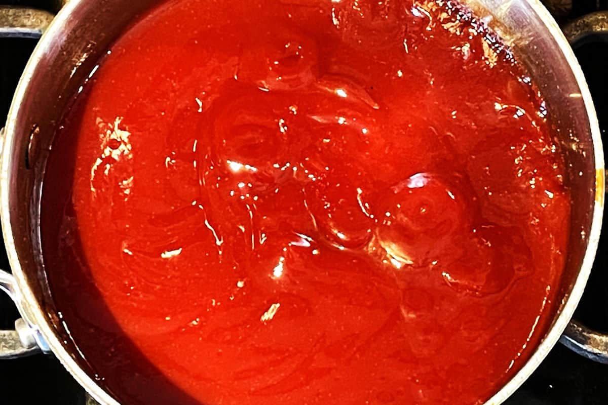 BBQ sauce ingredients simmering in saucepan on stove.