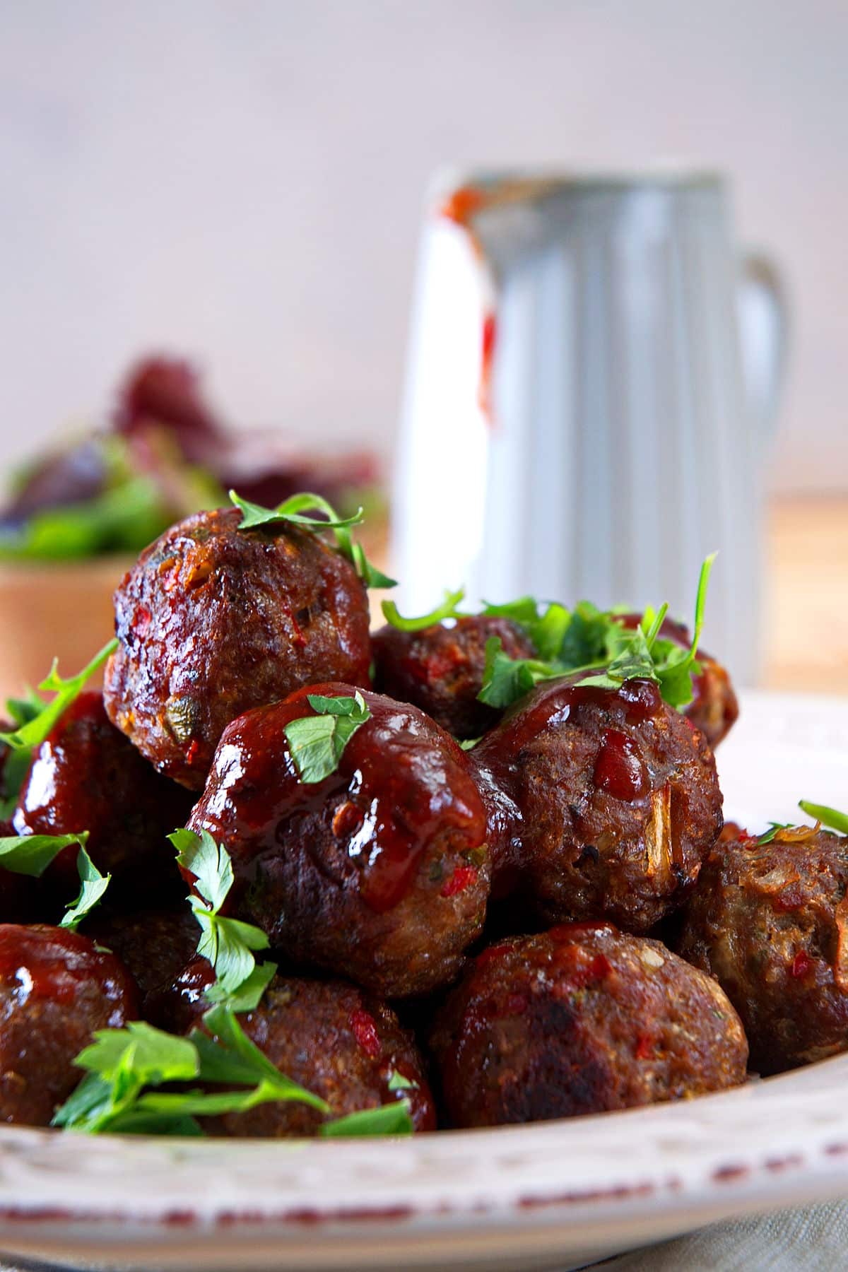 Bison meatballs in dish with freshly chopped parsley and homemade BBQ sauce.