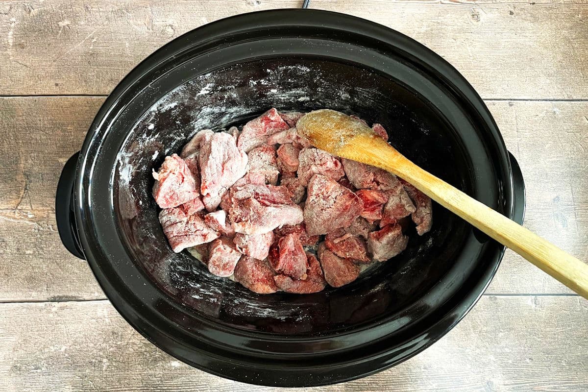 Bison stew meat in slow cooker with flour.