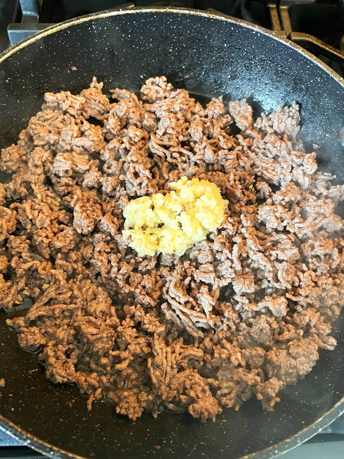 Ground bison in pan with garlic.