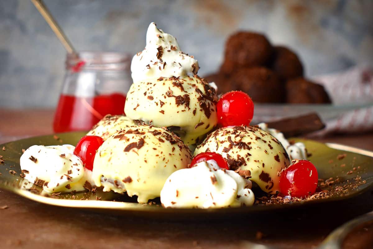Black Forest cake balls with whipped cream, maraschino cherries and grated chocolate.