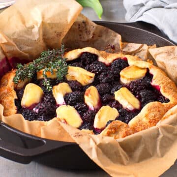 Blackberry galette with brie cheese and thyme in cast iron pan.