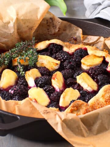 Blackberry galette with brie cheese and thyme in cast iron pan.