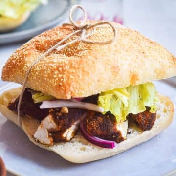 Blackened chicken sandwich tied together with twine.