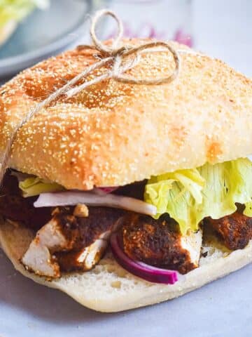 Blackened chicken sandwich tied together with twine.