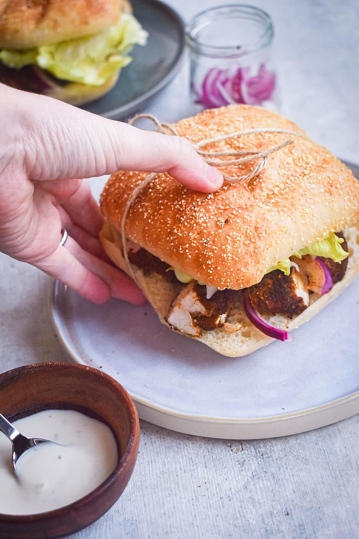 Blackened chicken sandwich held in a hand.
