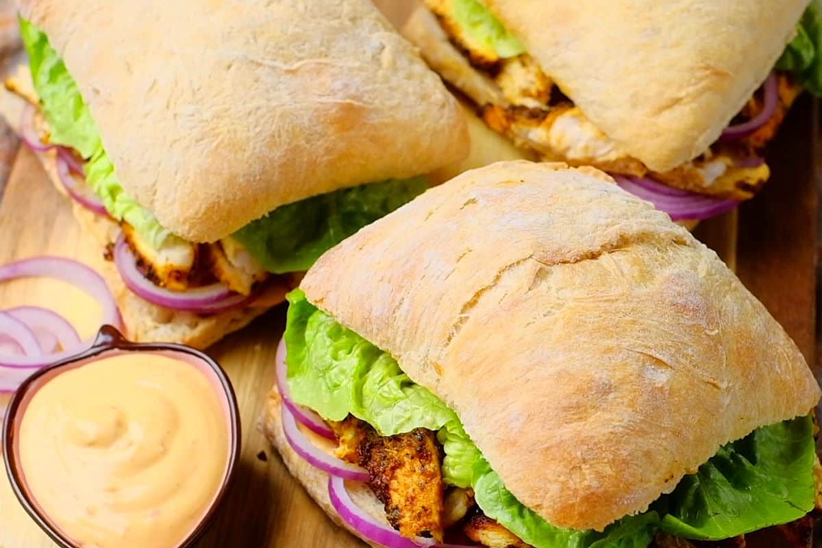 Blackened chicken sandwiches with spicy mayo on the side.