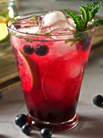 Blueberry mojito mocktail with fresh mint in cocktail glass.