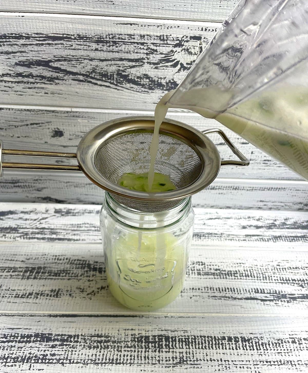 Brazilian lemonade getting strained into glass.
