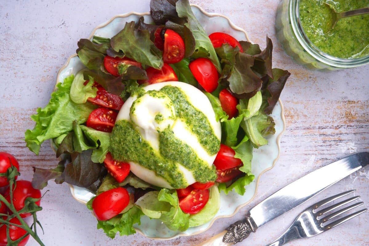 Burrata salad with cherry tomatoes on salad plate.