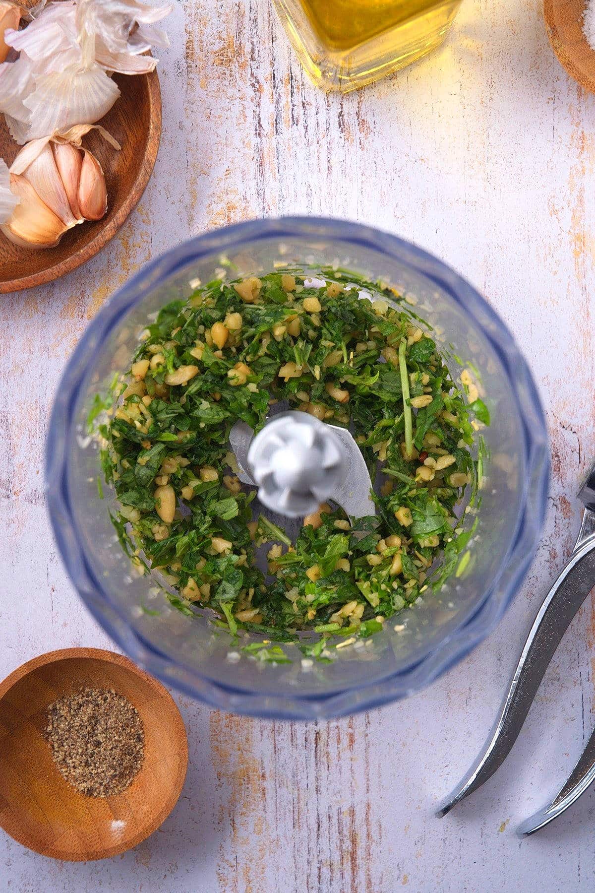 Basil pesto ingredients pulsed in food processor.
