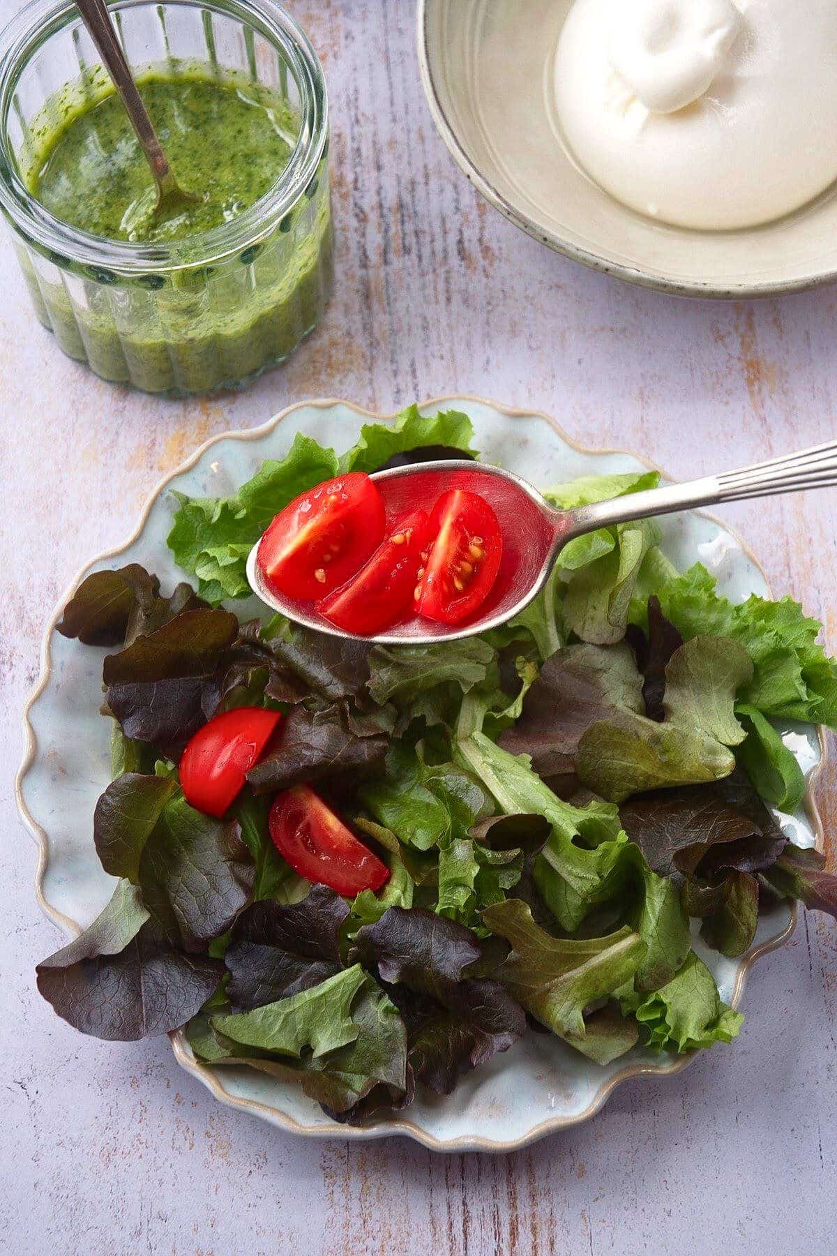 Cherry tomatoes and mixed salad greens on plate.