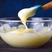 Cake pop frosting in bowl with spatula.