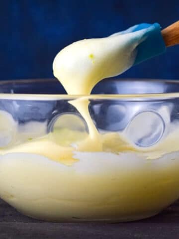 Cake pop frosting in bowl with spatula.