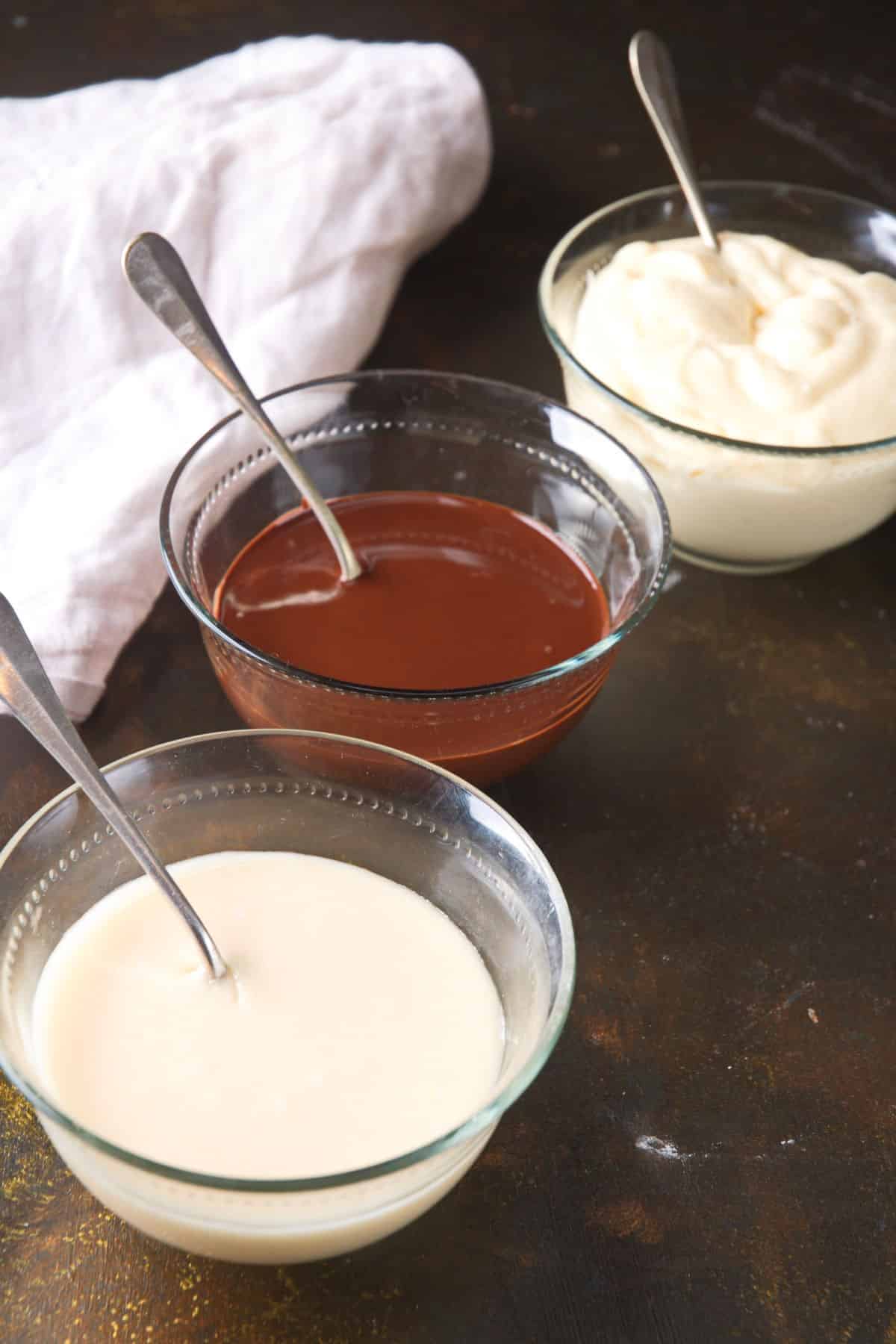 Cake pop frosting, icing and chocolate coating in bowls.