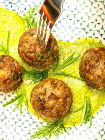 Mediterranea meatballs with fresh dill pesto on plate.