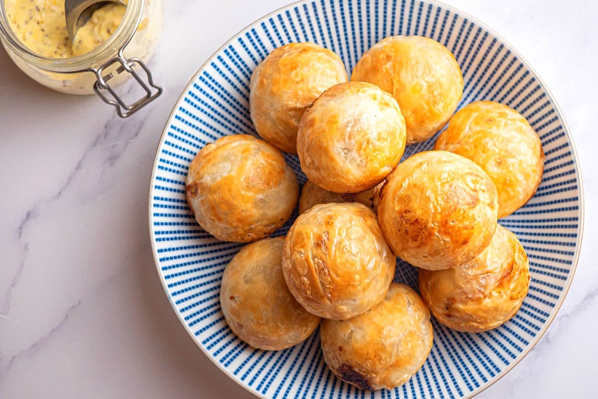Puff pastry chicken balls on blue and white plate.